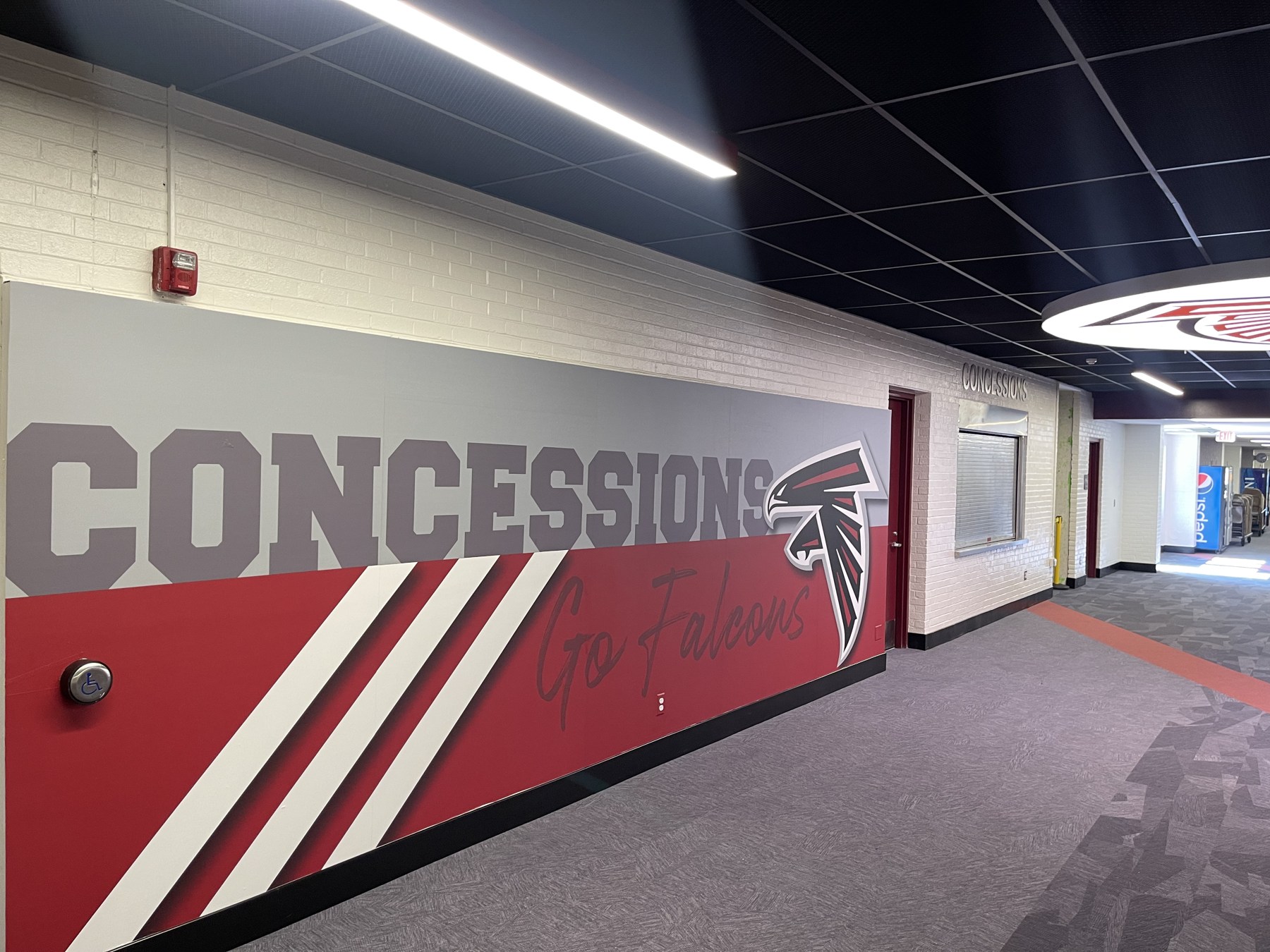 Interior corridor with patterned carpet, wall graphics and ceiling lighting